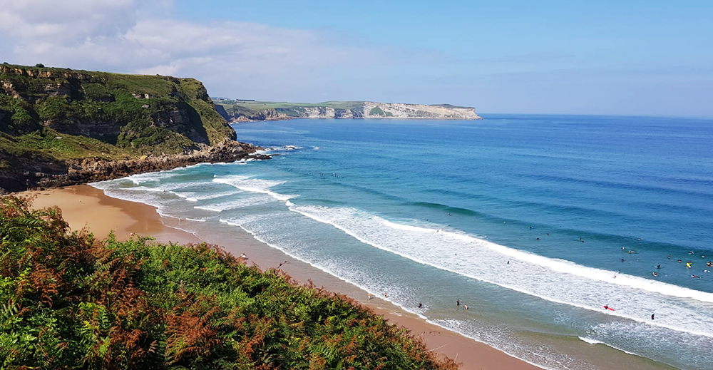 aprendiendo surf en la playa de los locos de suances